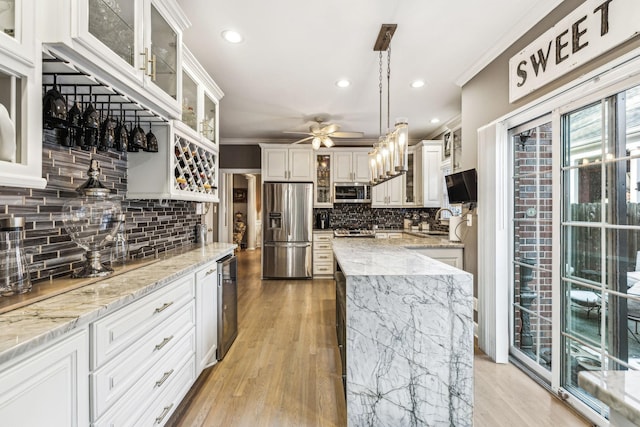 314 W 6th St, Columbia, TN 38401 - kitchen featuring appliances with stainless steel finishes, ornamental molding, ceiling fan, tasteful backsplash, and light wood-style floors