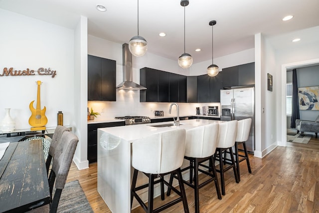 2910 Felicia St Unit 1, Nashville, TN 37209 - kitchen featuring stainless steel appliances, wall chimney exhaust hood, dark cabinetry, decorative backsplash, and light countertops