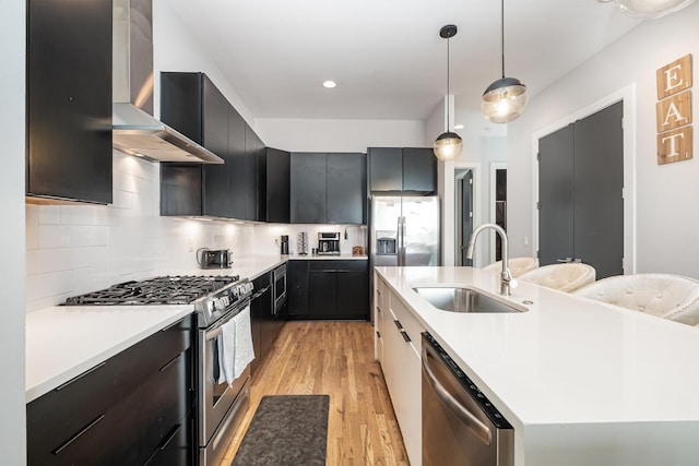 2910 Felicia St Unit 1, Nashville, TN 37209 - kitchen with appliances with stainless steel finishes, wall chimney range hood, a center island with sink, light wood-type flooring, and light countertops