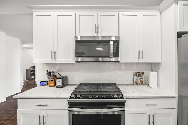 516 Delacy Dr, Fairview, TN 37062 - kitchen with appliances with stainless steel finishes, dark wood-style floors, white cabinetry, tasteful backsplash, and light stone counters