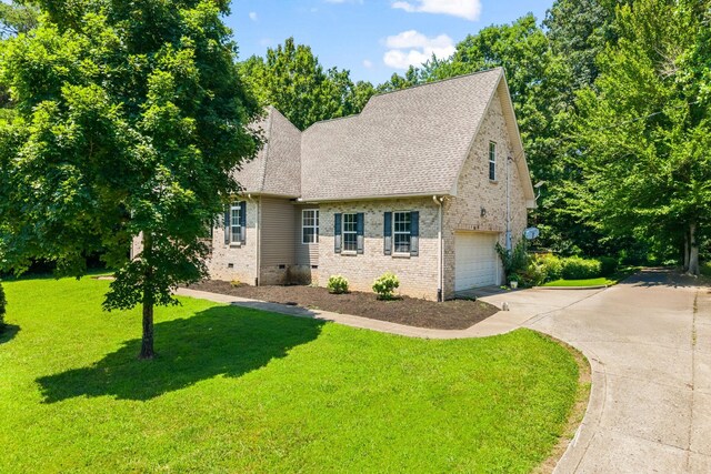 516 Delacy Dr, Fairview, TN 37062 - view of front of home with driveway, an attached garage, roof with shingles, a front yard, and brick siding
