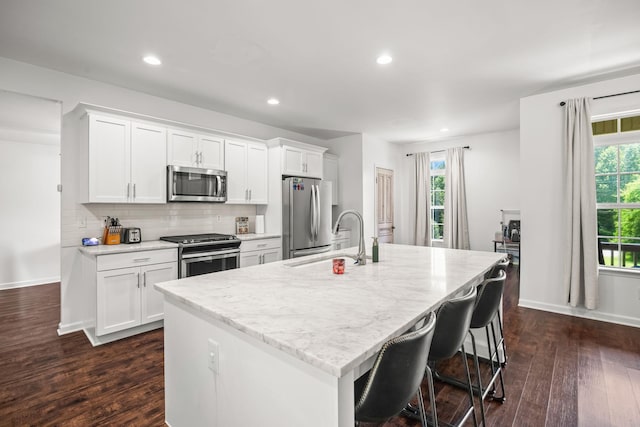 516 Delacy Dr, Fairview, TN 37062 - kitchen featuring stainless steel appliances, a center island with sink, dark wood-style flooring, white cabinetry, and recessed lighting