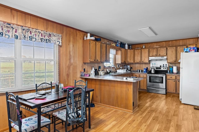 313 S Old Military Rd, Saint Joseph, TN 38481 - kitchen featuring freestanding refrigerator, stainless steel electric range oven, under cabinet range hood, brown cabinets, and wood walls