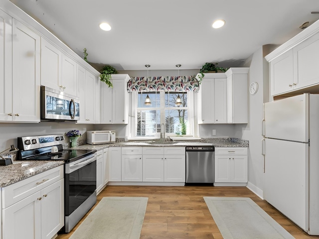 506 Bill Fuson Rd, Mcminnville, TN 37110 - kitchen with appliances with stainless steel finishes, white cabinetry, light wood-style flooring, recessed lighting, and light stone counters
