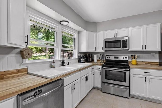 3474 Lockwood Cir, Chattanooga, TN 37415 - kitchen featuring stainless steel appliances, butcher block countertops, white cabinetry, and light tile patterned floors