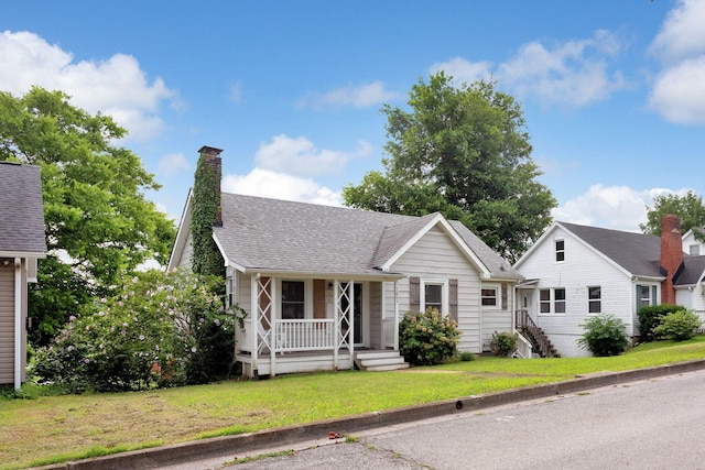 1803 Dimple Ct, Columbia, TN 38401 - view of front of house featuring covered porch, a front yard, a shingled roof, and a chimney