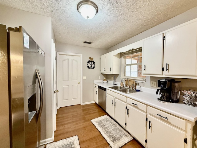 1252 Azure Way, Murfreesboro, TN 37128 - kitchen featuring stainless steel appliances, light countertops, wood finished floors, white cabinetry, and a textured ceiling