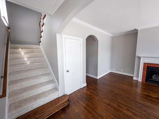 527 32nd Ave S, Nashville, TN 37212 - staircase featuring arched walkways, ornamental molding, wood finished floors, and a tiled fireplace