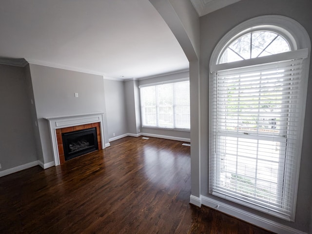 527 32nd Ave S, Nashville, TN 37212 - unfurnished living room featuring plenty of natural light, a tile fireplace, dark wood finished floors, arched walkways, and ornamental molding