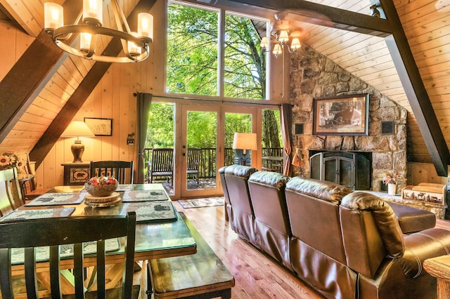 1530 Zurich Rd, Gatlinburg, TN 37738 - living area with a chandelier, wood finished floors, a wooden ceiling with exposed beams, wooden walls, and plenty of natural light