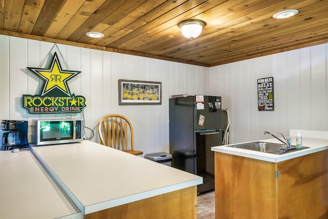 1530 Zurich Rd, Gatlinburg, TN 37738 - kitchen with freestanding refrigerator, stainless steel microwave, wood ceiling, brown cabinets, and light countertops