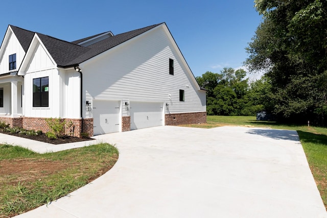 19 Peyton Pl, Columbia, TN 38401 - view of side of property with board and batten siding, a shingled roof, concrete driveway, a lawn, and brick siding
