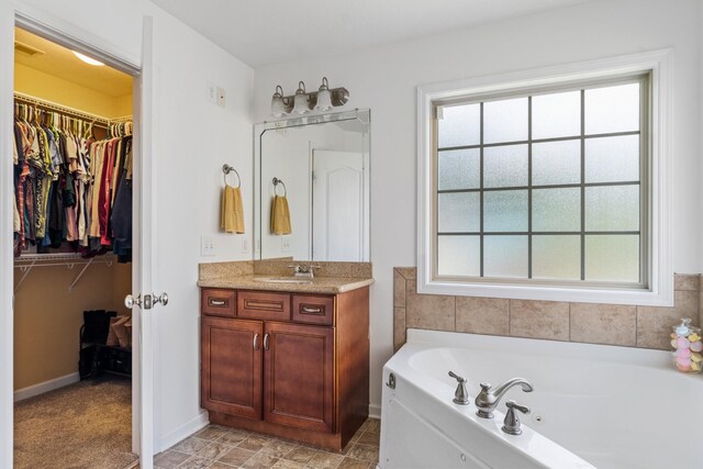 1386 Bruceton Dr, Clarksville, TN 37042 - full bath with vanity, healthy amount of natural light, a tub with jets, and a walk in closet