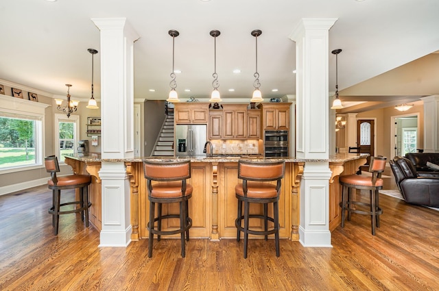 517 Burnett Rd, Mount Juliet, TN 37122 - kitchen with stainless steel refrigerator with ice dispenser, ornate columns, tasteful backsplash, wood finished floors, and ornamental molding