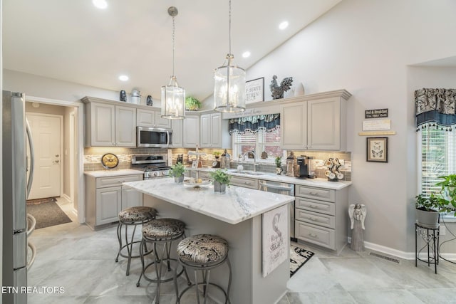 187 Forest View Dr, Crossville, TN 38558 - kitchen featuring stainless steel appliances, a kitchen island, gray cabinets, a breakfast bar area, and backsplash