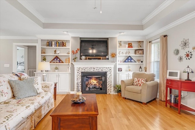 379 Hooper Rd, Winchester, TN 37398 - living area with a raised ceiling, light wood-style floors, a tile fireplace, ornamental molding, and built in shelves