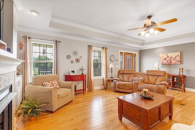 379 Hooper Rd, Winchester, TN 37398 - living room featuring a raised ceiling, a fireplace, a ceiling fan, light wood-style floors, and ornamental molding
