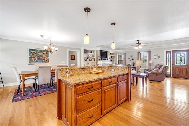 379 Hooper Rd, Winchester, TN 37398 - kitchen featuring light wood-style floors, crown molding, light stone counters, pendant lighting, and open floor plan
