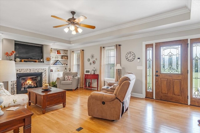 379 Hooper Rd, Winchester, TN 37398 - living room featuring light wood-type flooring, a ceiling fan, ornamental molding, a fireplace, and a tray ceiling