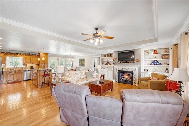 379 Hooper Rd, Winchester, TN 37398 - living room featuring light wood finished floors, a tray ceiling, a ceiling fan, a tiled fireplace, and ornamental molding