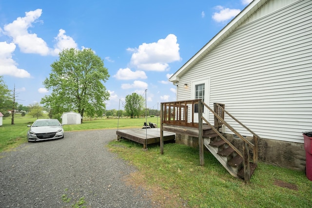 105 Gammons Ln, Lafayette, TN 37083 - view of green lawn featuring a wooden deck, a shed, and gravel driveway