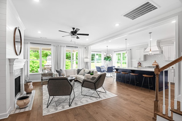 2636 Bramblewood Ln, Thompsons Station, TN 37179 - living area featuring a ceiling fan, healthy amount of natural light, wood finished floors, crown molding, and a fireplace with raised hearth
