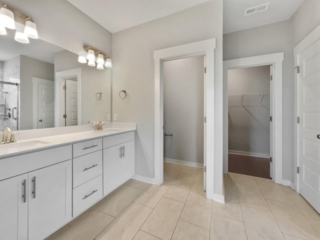 795 Ewell Farm Dr, Spring Hill, TN 37174 - full bathroom featuring double vanity, a walk in closet, a stall shower, and tile patterned floors