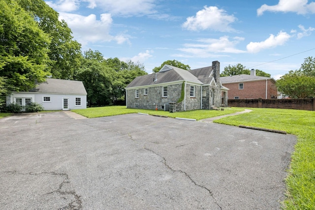 234 4th Ave N, Franklin, TN 37064 - view of front of property featuring stone siding, a front yard, uncovered parking, and a chimney