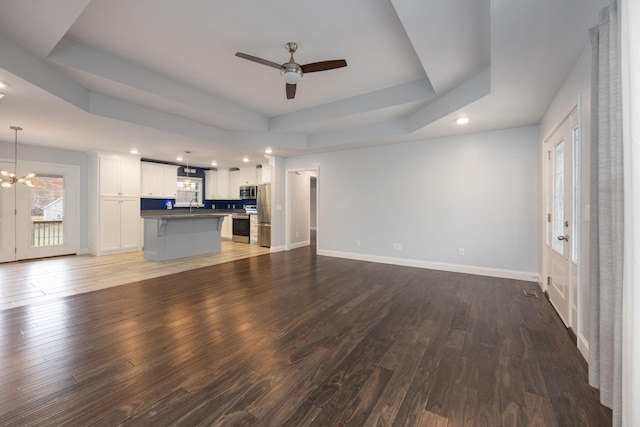 33 Maple Ln, Summertown, TN 38483 - unfurnished living room with a raised ceiling, ceiling fan, recessed lighting, wood finished floors, and a chandelier