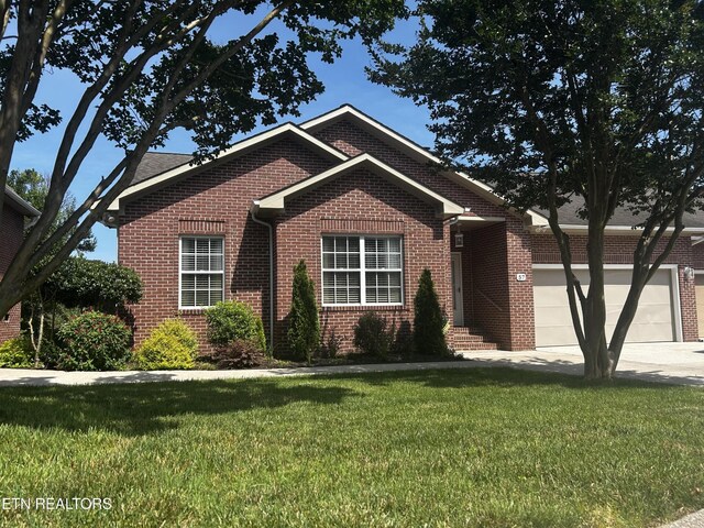 57 Riverview Dr, Oak Ridge, TN 37830 - view of front of house with brick siding, a garage, a front lawn, and concrete driveway