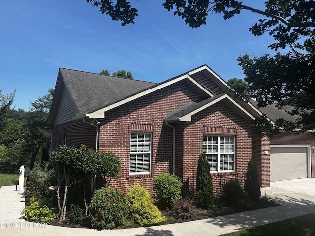 57 Riverview Dr, Oak Ridge, TN 37830 - view of side of home featuring brick siding, concrete driveway, a shingled roof, and a garage