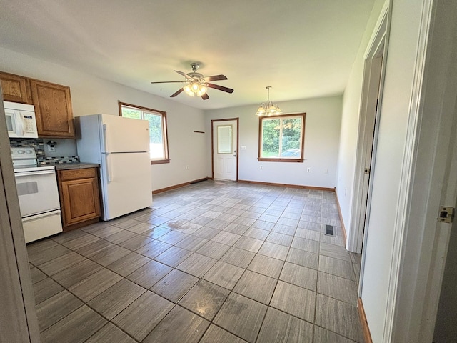 571 E Main St, Auburn, KY 42206 - kitchen featuring white appliances, brown cabinets, and healthy amount of natural light