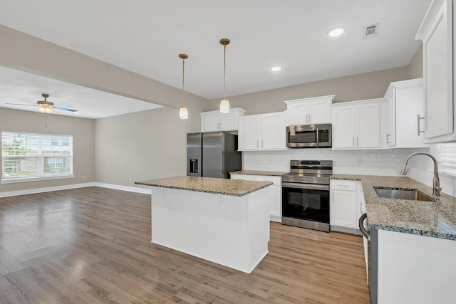 127 Dry Creek Commons Dr, Goodlettsville, TN 37072 - kitchen featuring appliances with stainless steel finishes, decorative backsplash, light stone countertops, white cabinets, and recessed lighting