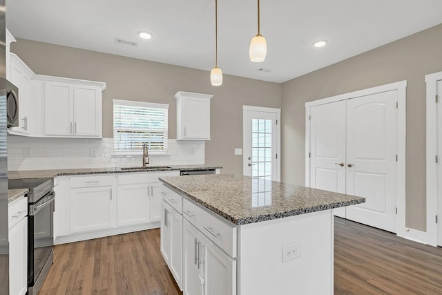 127 Dry Creek Commons Dr, Goodlettsville, TN 37072 - kitchen with electric range, light wood-style floors, decorative backsplash, a center island, and white cabinetry