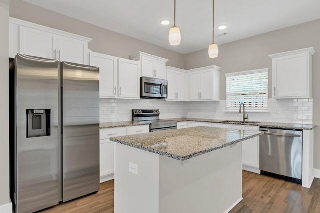 127 Dry Creek Commons Dr, Goodlettsville, TN 37072 - kitchen featuring appliances with stainless steel finishes, white cabinets, light wood finished floors, a kitchen island, and light stone counters