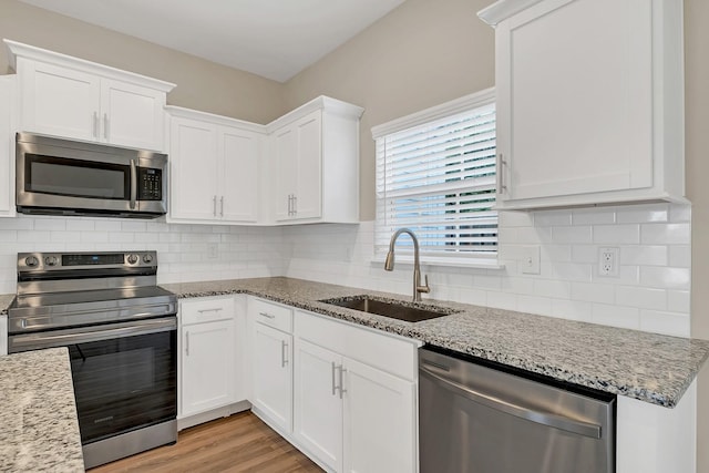 127 Dry Creek Commons Dr, Goodlettsville, TN 37072 - kitchen with stainless steel appliances, white cabinets, light wood-type flooring, and light stone countertops