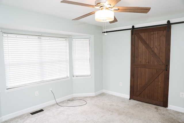 31 Community Rd, Lawrenceburg, TN 38464 - unfurnished bedroom featuring light colored carpet, a barn door, and a ceiling fan
