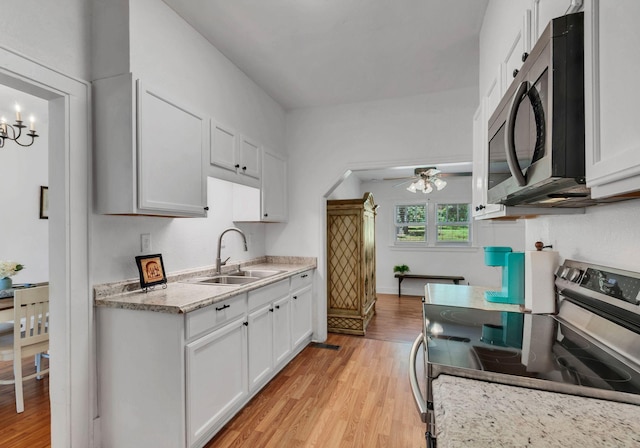 203 6th Ave, Columbia, TN 38401 - kitchen featuring appliances with stainless steel finishes, light wood-style floors, white cabinetry, a ceiling fan, and a chandelier