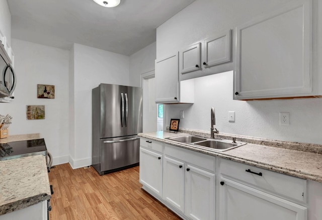 203 6th Ave, Columbia, TN 38401 - kitchen with freestanding refrigerator, light wood-style flooring, white cabinetry, and electric range oven