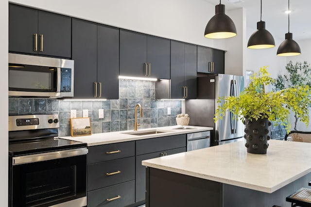1014 16th Ave S Unit 103, Nashville, TN 37212 - kitchen featuring appliances with stainless steel finishes, backsplash, pendant lighting, a center island, and dark cabinets