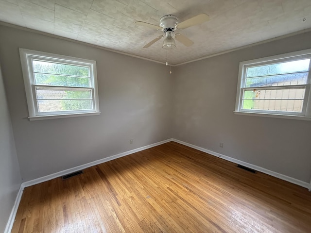 125 Benco Ln, Camden, TN 38320 - unfurnished room with healthy amount of natural light, light wood finished floors, ceiling fan, and ornamental molding