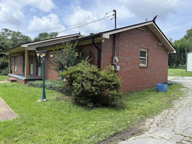 125 Benco Ln, Camden, TN 38320 - view of home's exterior featuring brick siding, a lawn, and covered porch