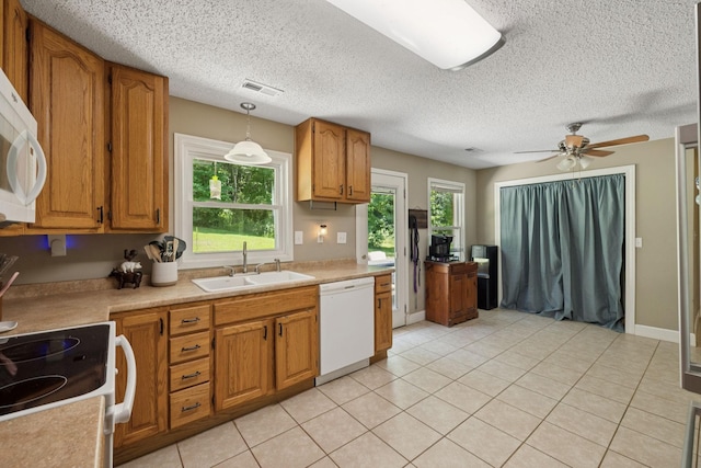5 Old Chisholm Creek Rd, Lawrenceburg, TN 38464 - kitchen featuring white appliances, healthy amount of natural light, brown cabinetry, and a textured ceiling