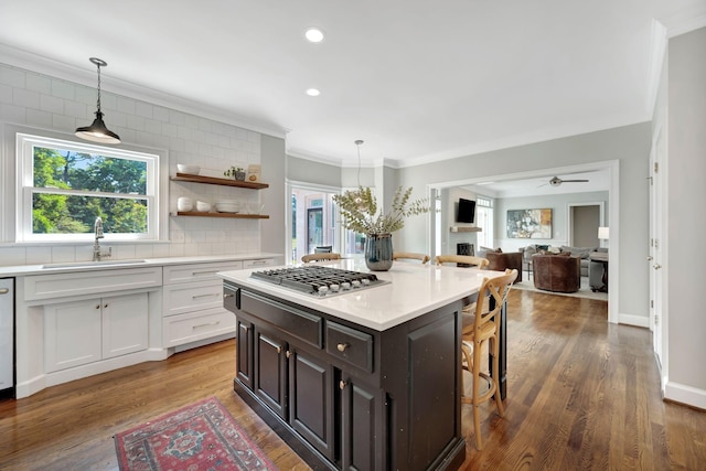 904 Oxford Ct, Brentwood, TN 37027 - kitchen with stainless steel gas stovetop, a breakfast bar, light countertops, backsplash, and ornamental molding