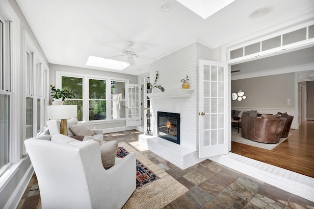 904 Oxford Ct, Brentwood, TN 37027 - living area with a skylight, a brick fireplace, a ceiling fan, and stone finish floors
