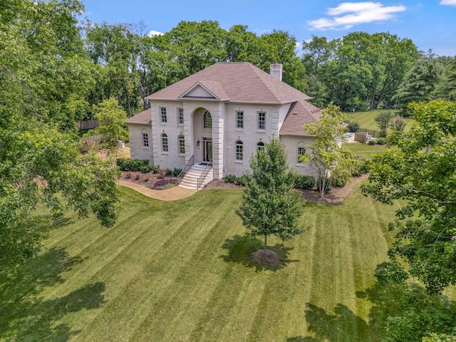 904 Oxford Ct, Brentwood, TN 37027 - view of front facade featuring a chimney, a front yard, view of wooded area, and roof with shingles