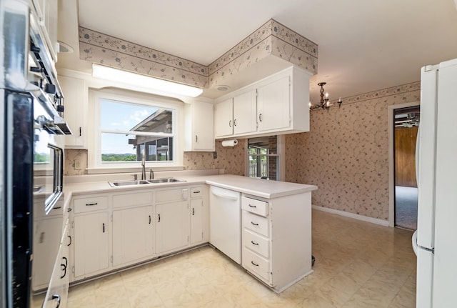 2208 Bowman Rd, Franklin, TN 37064 - kitchen with white appliances, wallpapered walls, a peninsula, light flooring, and a chandelier