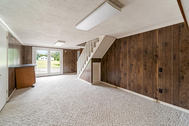 2208 Bowman Rd, Franklin, TN 37064 - basement with a textured ceiling, wooden walls, stairs, carpet floors, and ornamental molding