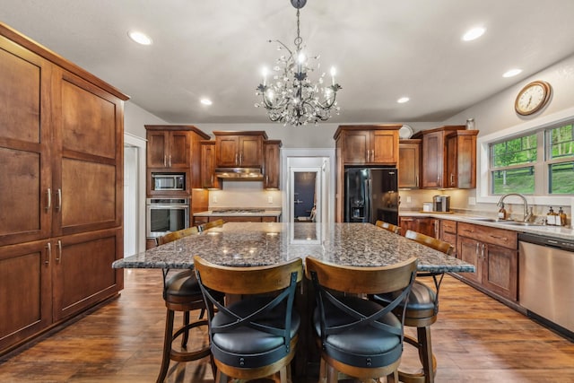 3092 Morel Rd, Columbia, TN 38401 - kitchen with stainless steel appliances, a center island, a breakfast bar, a chandelier, and dark wood-type flooring