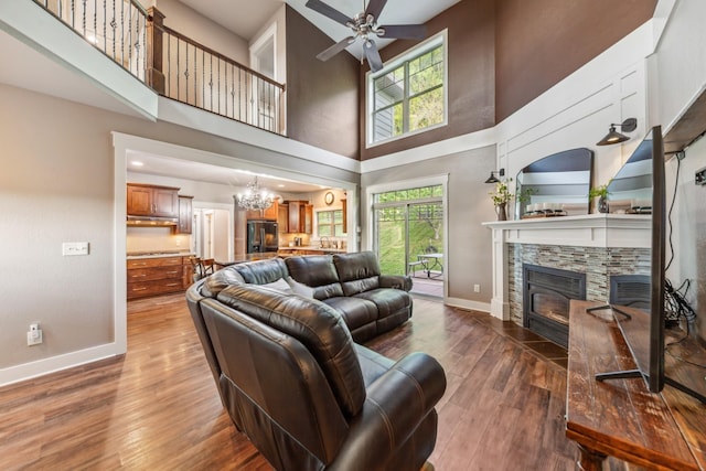 3092 Morel Rd, Columbia, TN 38401 - living area with a high ceiling, a stone fireplace, wood finished floors, a ceiling fan, and a chandelier
